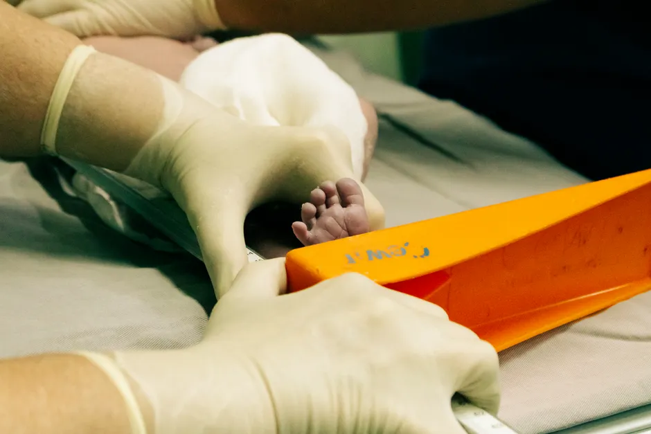 Hospital staff holding a newborn's foot shortly after birth